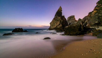 Rocky coast with soft waves under a sky with purple and blue hues at twilight