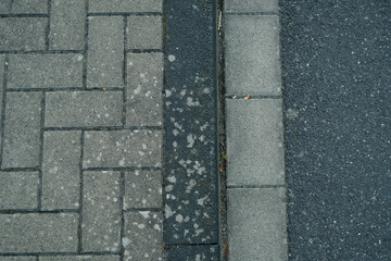 Fototapeta premium A brick sidewalk with a black line separating it from the street