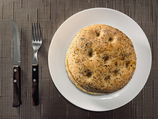 Focaccia bread serving on plate with cutlery