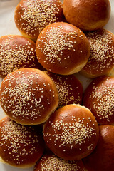 Close-up of freshly baked brioche buns with golden crust and sesame seeds. Soft and fluffy homemade bread, perfect for burgers or sandwiches.
