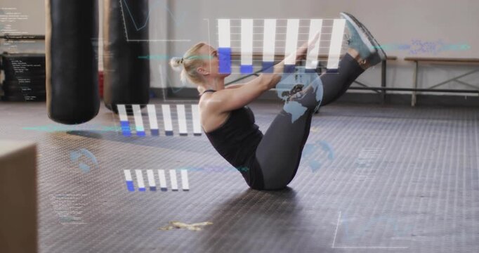 Pausing on rubber mat, engaging core, woman lifting arms and legs into V-up for fitness training