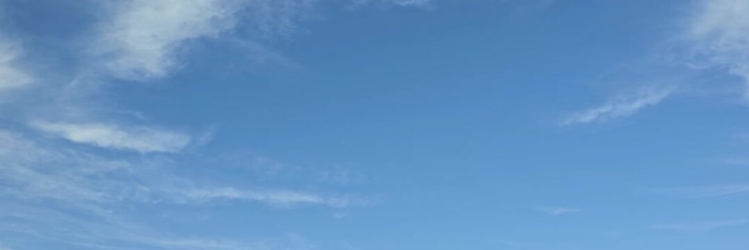 Cloudscape, Timelapse of beautiful blue sky with scattered wispy clouds on horizon, for wide background	