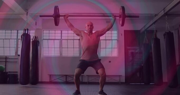Gym weightlifter bending hips and gripping barbell driving legs and squatting under it snatching