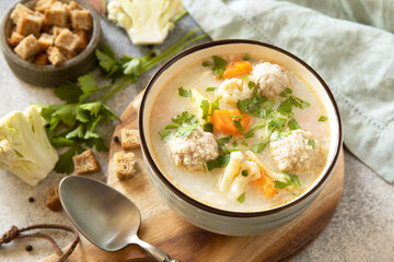 Hearty meatball soup with vegetables and herbs for a cozy meal.