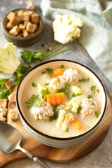 Hearty meatball soup with vegetables and herbs for a cozy meal.