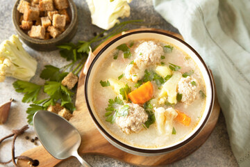 Hearty meatball soup with vegetables and herbs for a cozy meal
