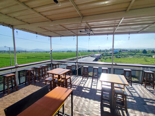 Relaxed atmosphere in an open cafe with natural views. Cafe in a river and rice field area in Indonesia.