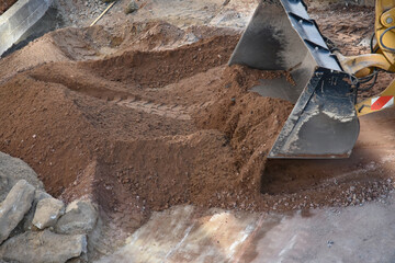 Yellow excavator moving soil at construction site

