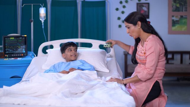 An affectionate Indian mother and her little son playing with a toy car in the hospital - fun and entertainment. An adorable kid with his single mother in the hospital - health and medical  togethe...