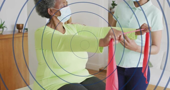 Female patient receiving red band from therapist then lifting arms for rehab posture improvement