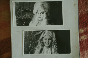 Uralsk, Kazakhstan - 22 January, 2025: Black and white old photos of girls, new year. Photo album with photo. Life values concept. Little girl in kindergarten at a matinee. Retro or vintage photo.