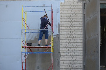 Man painting the wall gray with a roller. High quality photo