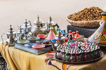 Souvenir stall in Morocco full of metal teapots, typical local food products and other decorative details that tourists can buy as souvenirs.