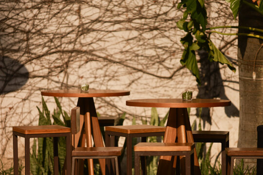 Mesas e bancos de madeira em &aacute;rea externa, criando ambiente elegante e funcional para conviv&ecirc;ncia e eventos.