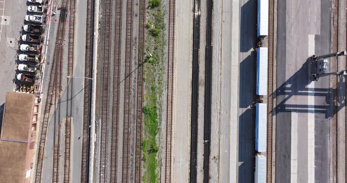 Straight down aerial video of several, many, parallel railroad tracks in a rail yard.