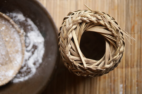 Processo tradicional da farinha de mandioca: tacho de torrar farinha, farinha branca e tipiti de palha usado para prensar a mandioca ralada.