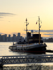 Fototapeta premium Vintage Tugboat at Sunset with Vancouver Skyline in Background