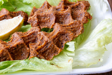 Making raw meatballs ( Turkish: Cig Kofte ) on wooden background	