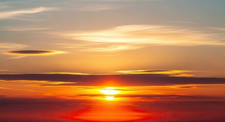 Obraz premium A vibrant sunset with orange and red hues illuminating the sky and wispy clouds at the horizon line