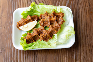 Making raw meatballs ( Turkish: Cig Kofte ) on wooden background	