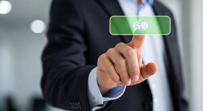 A man in a suit presses a green button that says go with his finger in a blurred background