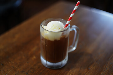 Root Beer Float with Vanilla Ice Cream and Red Striped Straw in a Mug on a Wooden Table 405e photo