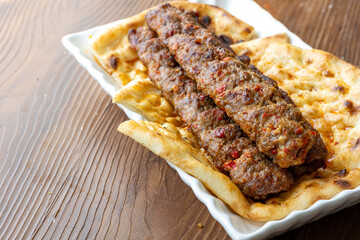 Close-up of traditional Turkish shish kebabs on oval plate