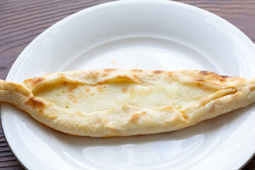 Close-Up of a Mini Turkish Cheese Pide on a White Plate