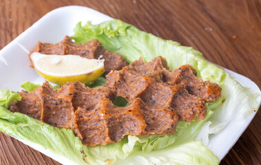 Making raw meatballs ( Turkish: Cig Kofte ) on wooden background	