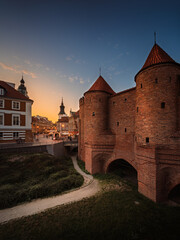 Złoty zachód słońca na warszawskiej Starówce z widokiem na zabytkowy Barbakan