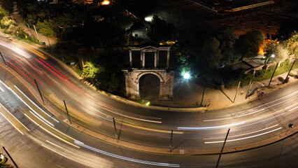 Aerial drone slow shutter night shot of illuminated Gate of Hadrian in historic centre of Athens,...
