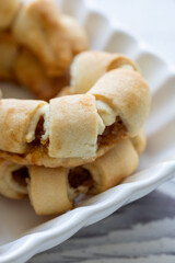 Close-Up of U-Shaped Apple Cookies on a Rectangular Plate on a White Wooden Surface
