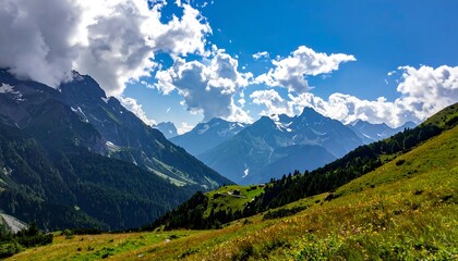 Sunny mountain vista; green hills, valley, and snow-capped peaks under a partly cloudy sky