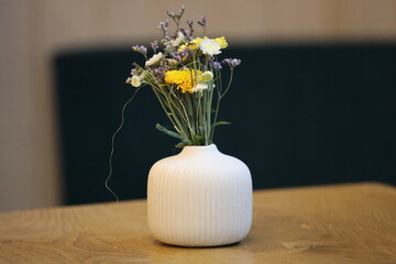 A beautiful vase filled with vibrant yellow and purple flowers, perfect for decorative or celebratory occasions