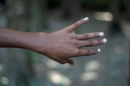 A persons hand is extended with fingers slightly spread - Powered by Adobe