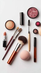Overhead shot of makeup products isolated on white background, including brushes, lipstick, mascara, and eyeshadow, arranged in an aesthetically pleasing layout