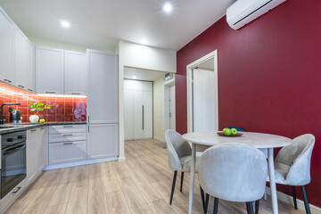 Minimalistic interior design of a modern living space with a kitchen and dining area.