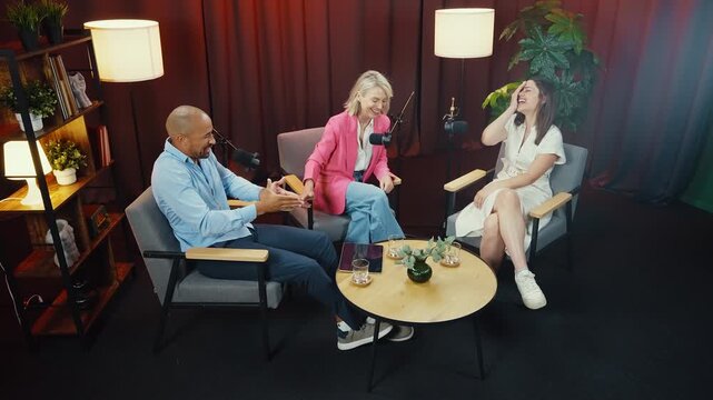 Podcast hosts engaging in lively conversation, sharing insights and anecdotes with their audience in a professional studio setting, illuminated by warm lighting and enhanced by soundproof curtains - Powered by Adobe