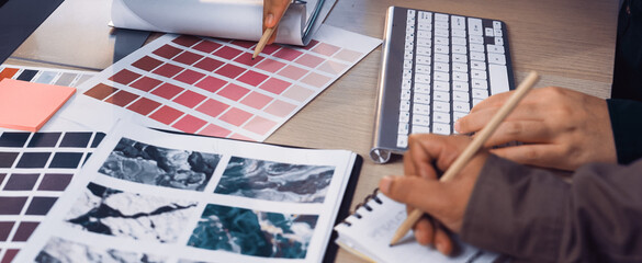 Two designers collaborate over color palettes, sketches, and digital tools, showcasing a creative workspace filled with inspiration for art and design projects. SACTR