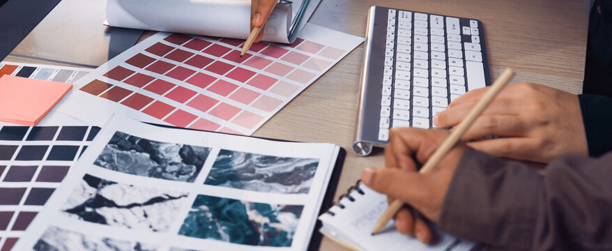 Two designers collaborate over color palettes, sketches, and digital tools, showcasing a creative workspace filled with inspiration for art and design projects. SACTR - Powered by Adobe