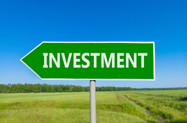Investment symbol. Concept word Investment on beautiful green road sign. Beautiful blue sky green grass and forest peaceful nature background. Business investment concept. Copy space.