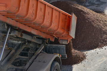 Fototapeta premium Dump truck unloading soil at construction site