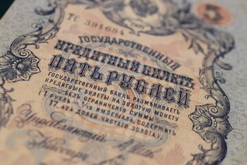Close-up of an old banknote featuring intricate designs and text in Russian, showcasing historical currency details