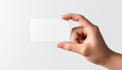 Obraz premium A hand holds a blank business card against a light gray background
