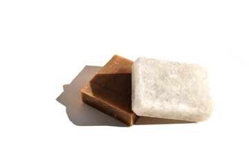 piece of soap with sea salt and square brown piece of natural soap isolated on white background top view