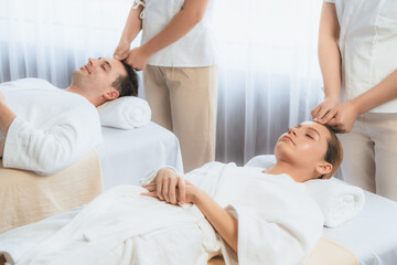 Obraz premium Caucasian couple enjoying relaxing anti-stress head massage and pampering facial beauty skin recreation leisure in dayspa modern light ambient at luxury resort or hotel spa salon. Quiescent