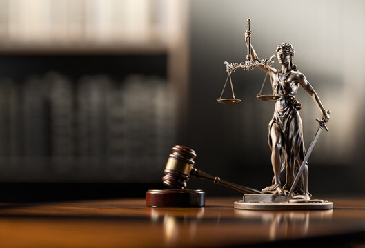 A close-up of a judge's gavel and law books.