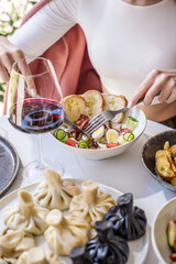 Woman with wine and salad at restaurant table