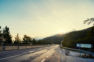 Mountain Road at Sunrise with Trees and Scenic Landscape