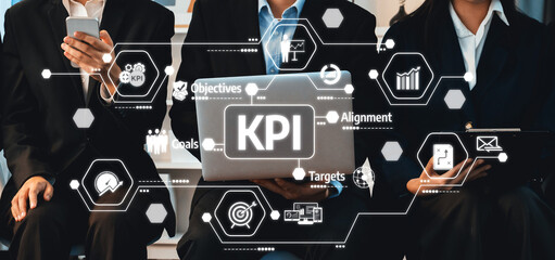 A diverse business team engaged in analyzing key performance indicators on a laptop in a sleek modern office, emphasizing strategy and goal alignment for organizational success. Amity